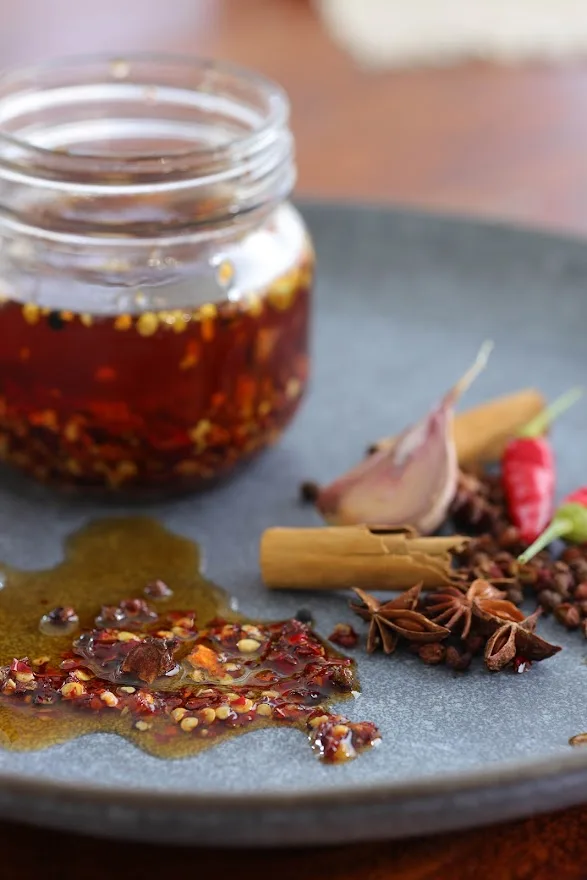 Chilli oil jar on plate with spilled oil and spices