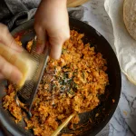 hand grating cheese over risotto