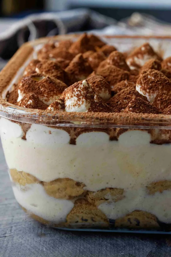 Glass dish of tiramisu showing layers and cream texture