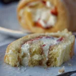 Slice of swiss roll cake with bite taken