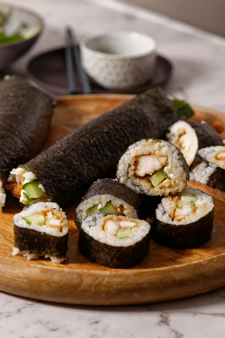 sliced sushi stacked on wooden plate