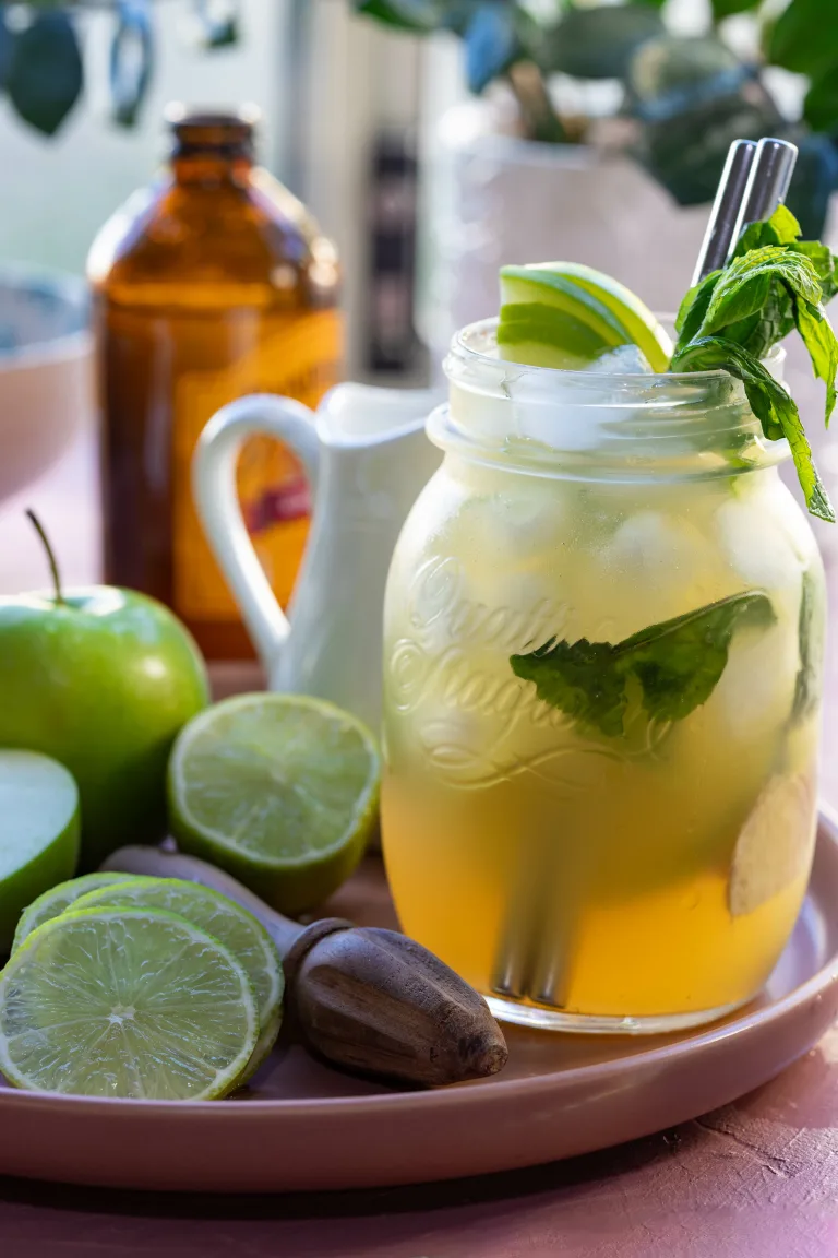 Bright and light summer mocktail in mason jar topped with fresh fruit and mint.
