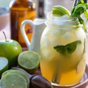 Bright and light summer mocktail in mason jar topped with fresh fruit and mint.