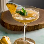 Pineapple yellow drink in coupe martini glass