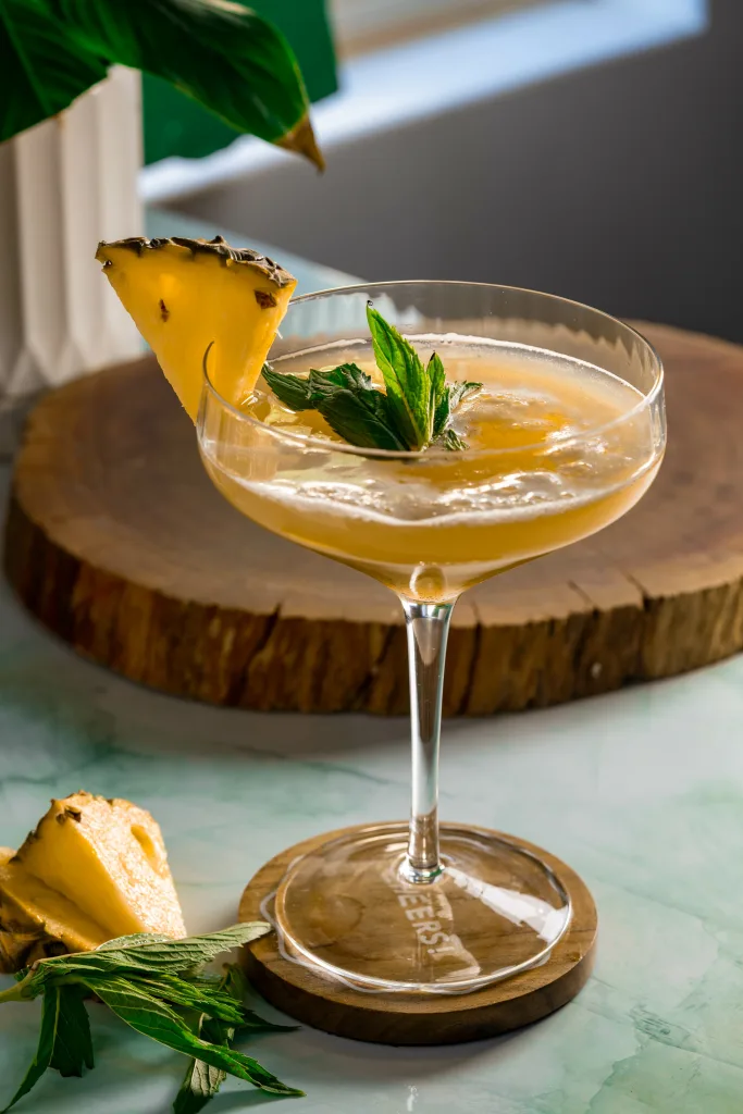 Pineapple yellow drink in coupe martini glass