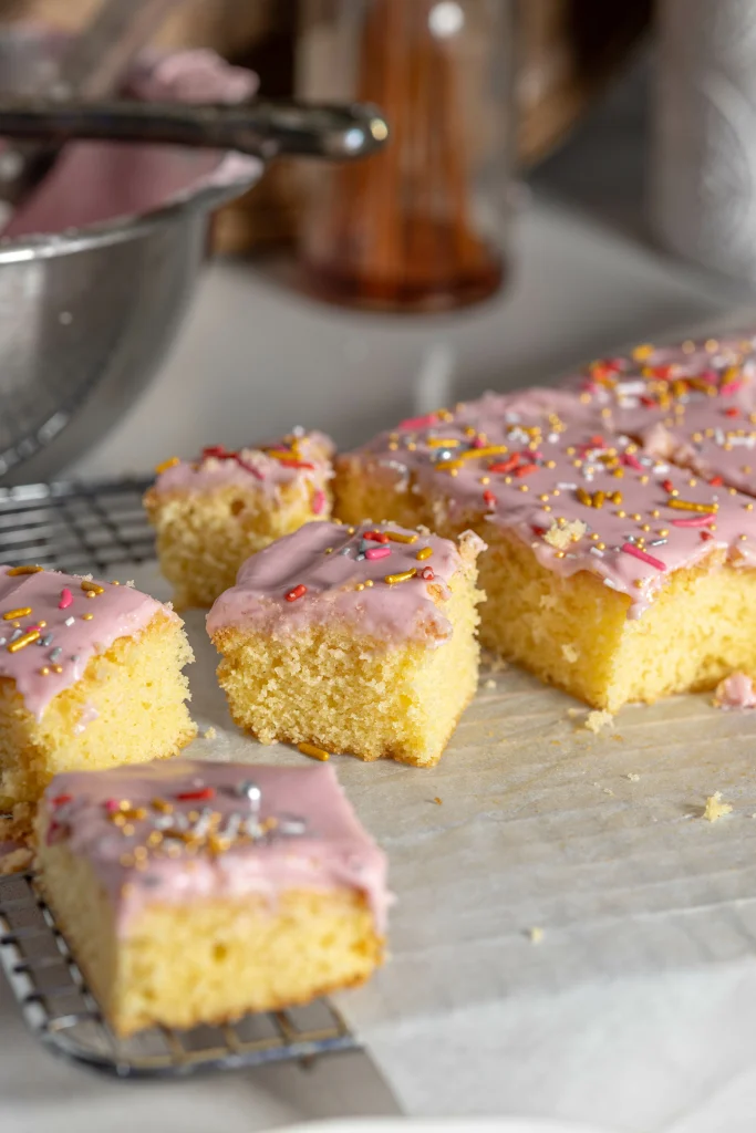 Lifestyle image of slice of snack cake sitting on baking paper and cooling rack.