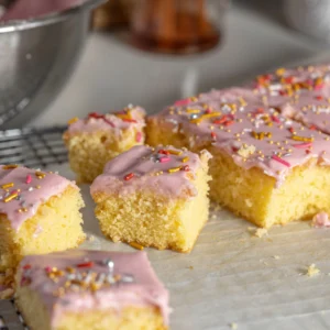 Lifestyle image of slice of snack cake sitting on baking paper and cooling rack.