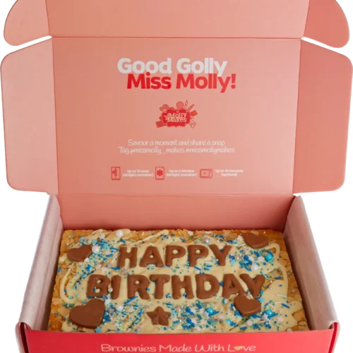 Slab of chocolate brownie decorated with blue sprinkles and milk chocolate letters spelling 'happy birthday'