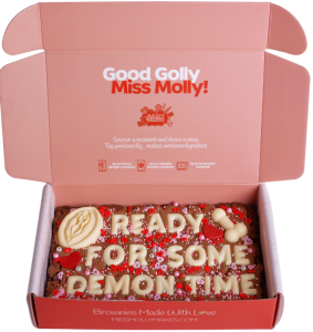 Naughty brownie slab with 'READY FOR SOME DEMON TIME' in white chocolate letters, vulva and penis choc icons and sprinkles