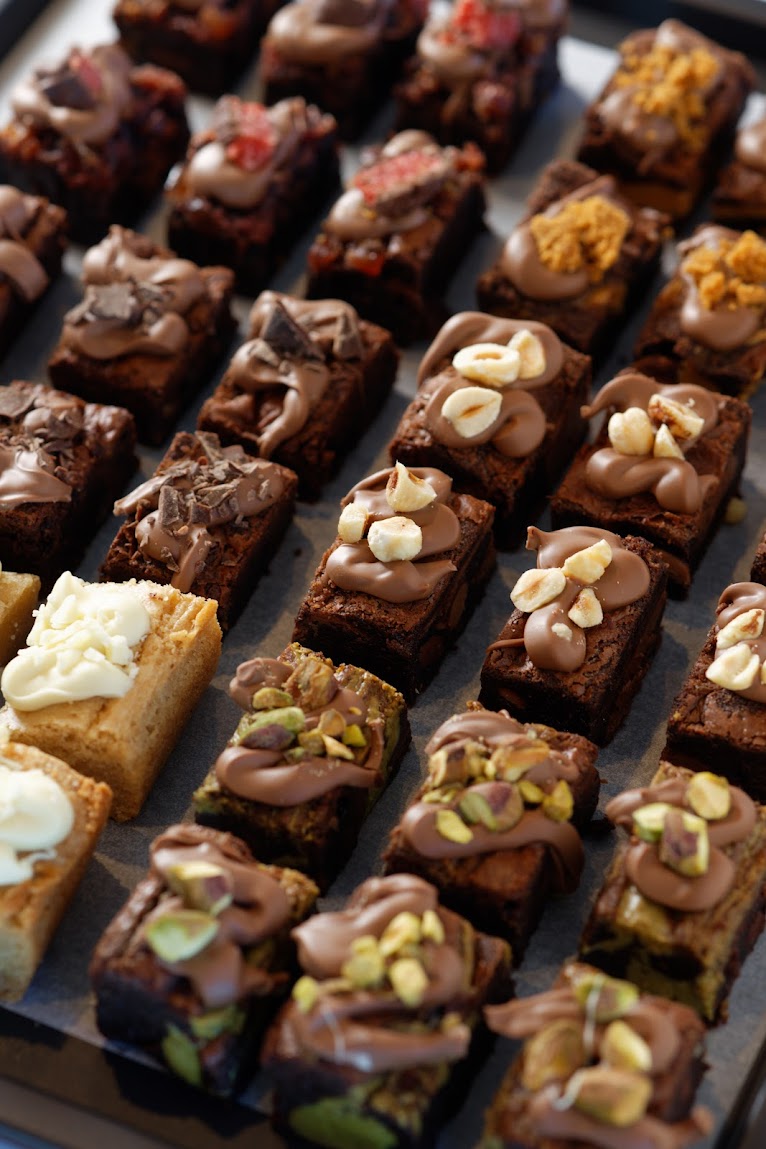 Rows and rows of flavoured brownies cut into bite sized pieces lined up neatly.