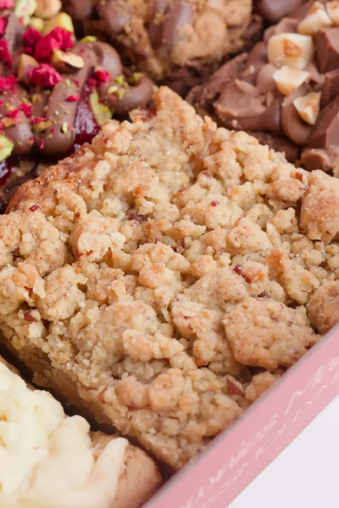 Close up of an apple crumble brownie with a golden oat crumble topping
