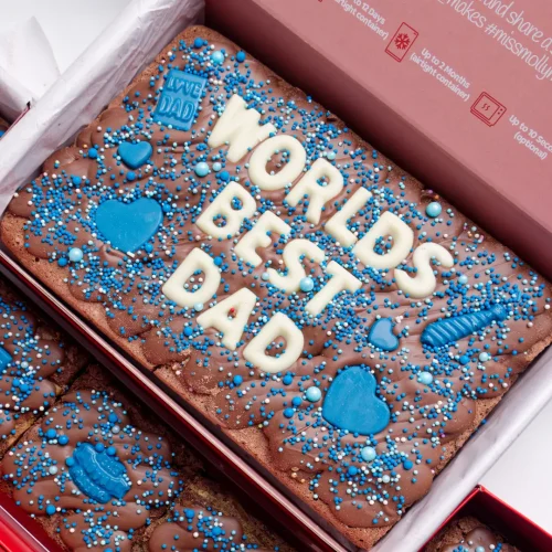 Chocolate brownie with tempered milk chocolate and 'Worlds best Dad' written in white choc text with blue sprinkles