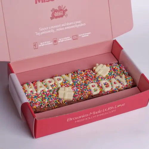 Birthday brownie slab spelling 'Happy B'Day' in white chocolate letters on rainbow sprinkles